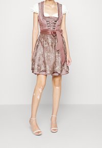 Robe traditionnelle avec un col carré, un laçage à l'avant et une jupe marron texturée et brodée. Accentuée par un ruban de taille en satin et une bordure en dentelle aux manches.