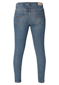 Smala denimjeans i medelblått, med bakfickor med chevrostygn och en liten läderlapp vid midjan.