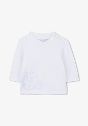 Witte langemouwen T-shirt van zachte katoen, met een lichtblauw cartoonontwerp van een wasbeer met de letter "B" onderaan. Twee drukknoopjes op de schouder.