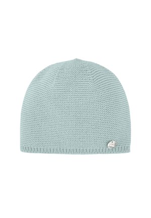 Bonnet tricoté bleu clair avec une texture douce et une forme arrondie. Il présente un petit logo métallique sur le côté.
