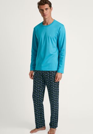Heren pyjama set met een turquoise lange mouw top en marineblauwe broek met groene bladbepalingen, gemaakt van zachte, ademende stof.