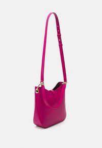 Magentanvärinen nahkainen olkalaukku, jossa on kaareva muoto, ohut säädettävä hihna, kullanväriset metalliosat ja sileä pinta.