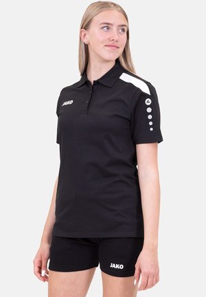 Polo shirt nero con design bicolore, caratterizzato da dettagli bianchi sulle spalle e un logo. Abbinato a pantaloni corti neri, entrambi realizzati in tessuto.