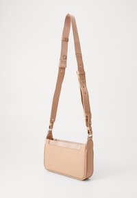 Μπεζ ορθογώνια τσάντα χειρός με υφή, ρυθμιζόμενος ιμάντας και μπροστινή τσέπη. Κατασκευασμένη από συνθετικό υλικό, με ασημένιες λεπτομέρειες.