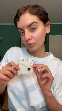 Kullast südamekujuline kaelakee Orelia kaardil; peenike kett, sile ja peegeldava pinnaga, esitatud neutraalsel taustal.