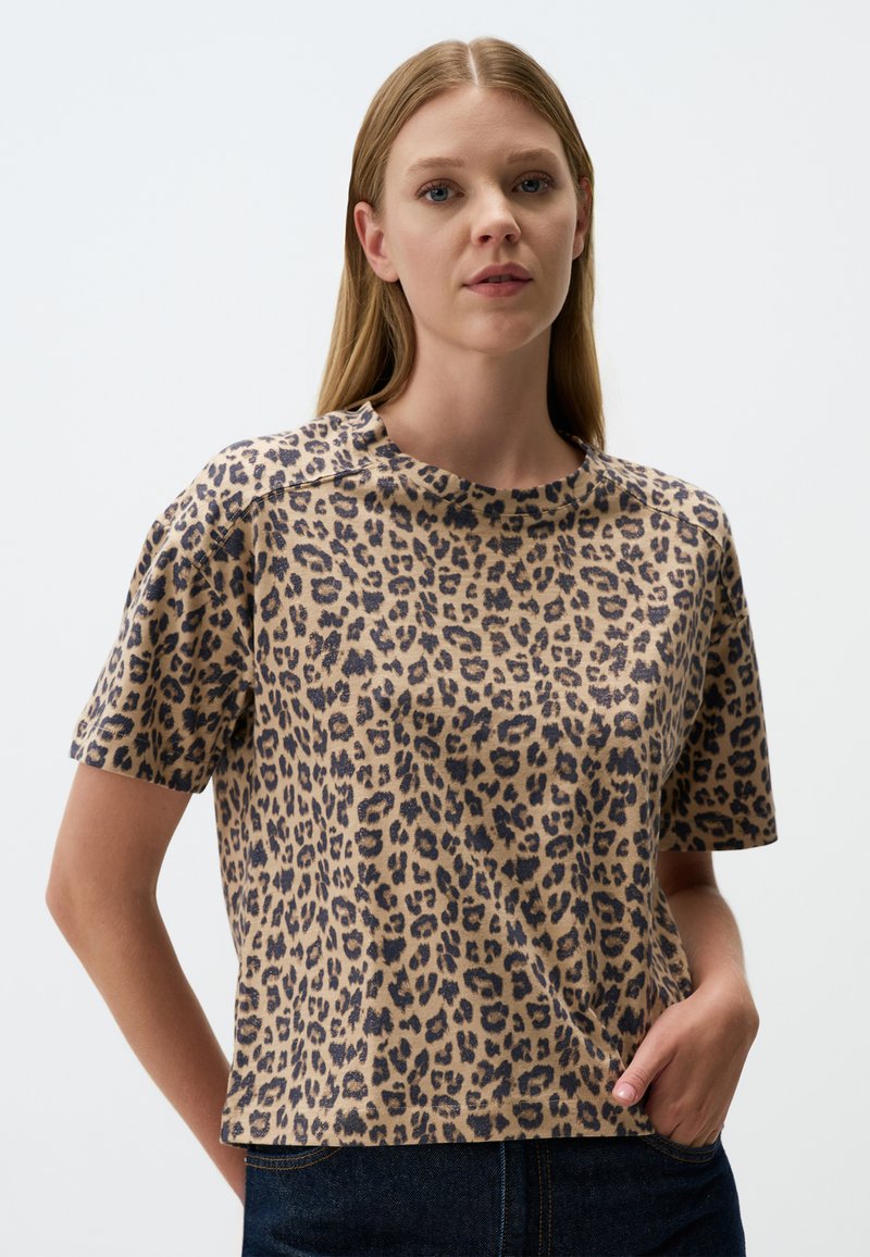 T-shirt en coton à manches courtes imprimé léopard, avec un col rond, une coupe décontractée et une texture douce ; nuances de beige et de noir.