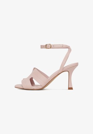 Sandalias de tacón rosa con acabado en cuero texturizado, que cuentan con dos tiras diagonales, una correa estrecha ajustable en el tobillo y un tacón cónico.