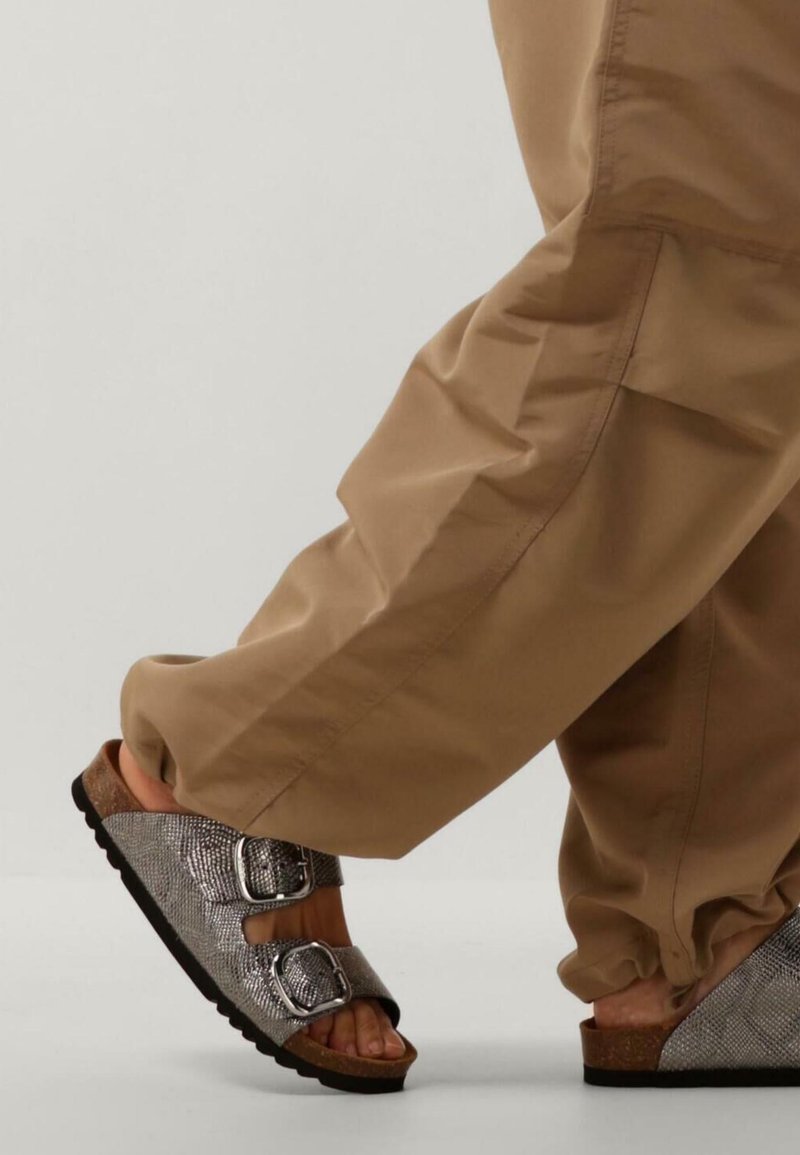 Grijze sandaaltjes met een slangenprint en twee verstelbare gespen, gecombineerd met losse khaki broek, wat een casual schoenenstijl laat zien.