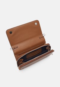 Brązowy skórzany portfel o fakturowanej powierzchni. Posiada zamek błyskawiczny, wiele przegródek na karty oraz przestronną główną komorę. Wnętrze wyściełane kolorem granatowym.