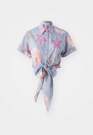 Camicetta a maniche corte con bottoni in azzurro chiaro, con un motivo floreale in rosa, viola e arancione. Presenta un dettaglio di nodo anteriore.