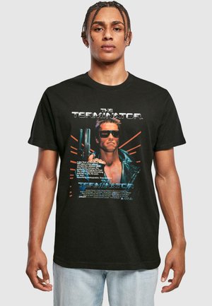 Sort bomulds t-shirt med "The Terminator" grafik, der viser et stiliseret billede af en karakter iført solbriller og fede tekst elementer.