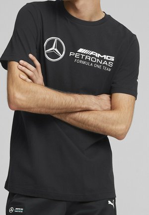 Czarny bawełniany t-shirt z okrągłym dekoltem. Z przodu znajduje się biały logo Mercedesa oraz napis "AMG PETRONAS Formula One Team".