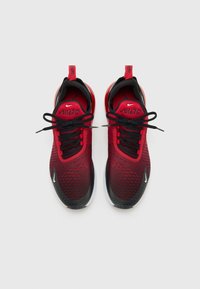 Červené tenisky Nike Air Max 270 s čiernymi akcentmi, sieťovinovým zvrškom, okrúhlou špičkou a plochými šnúrkami. Obsahujú logo na boku a pútko na päte.