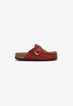 Sabot en suède rouge à enfiler avec une boucle dorée, semelle en liège et semelle en caoutchouc noire, présenté de profil sur un fond blanc.