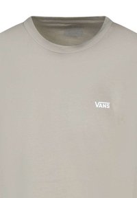 T-shirt di cotone beige chiaro con colletto rotondo, dotato di un piccolo logo Vans bianco sul lato sinistro del petto. Tessuto morbido, vestibilità casual.