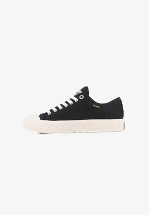 Black canvas sneaker with white rubber sole, featuring a textured diamond pattern, metal eyelets, and contrasting laces. Brand label on side.