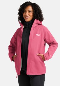 Roze waterdichte jas met capuchon, voorkant met rits en zijzakken. Heeft een logo op de borst en verstelbare manchetten. Gladde textuur.