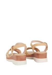 Sandali beige con dettagli intrecciati, cinturini alla caviglia regolabili e un tacco a cuneo bicolore marrone e bianco. Tessuto in pelle liscia in tutto il sandalo.