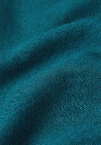 Teal fabric with a soft, textured surface, featuring a consistent weave and subtle variation in color depth. Ideal for garments or upholstery.