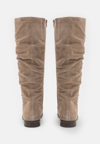Bottes en daim taupe, arrivant juste au genou, avec un design drapé, dotées de fermetures éclair et d'une finition lisse sur un petit talon carré.