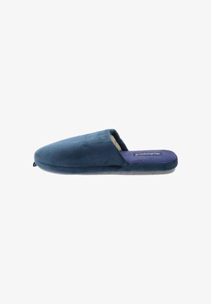Zapatilla azul marino hecha de tela suave con un interior acolchado, que presenta un perfil bajo, punta redondeada y plantilla texturizada morada.