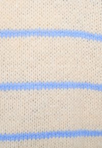 Κρεμ υφαντό ύφασμα με υφή και οριζόντιες μπλε ρίγες. Το υλικό φαίνεται μαλακό και ζεστό.