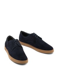 Zapatos de ante azul marino con una textura suave, puntera redonda y suelas de goma. Presentan costuras tonales y un diseño clásico con cordones.