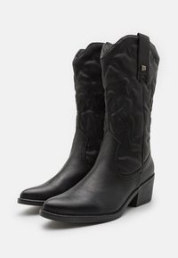 Černé kožené kovbojské boty s špičatými špičkami, dekorativním prošíváním na holeni a malým podpatkem. Mají poutko pro snadné obouvání.