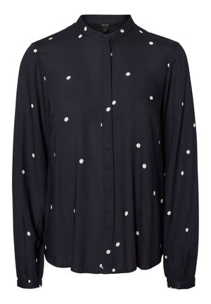 Blusa azul marino de manga larga con lunares blancos, cuello mandarín y cierre frontal con botones.