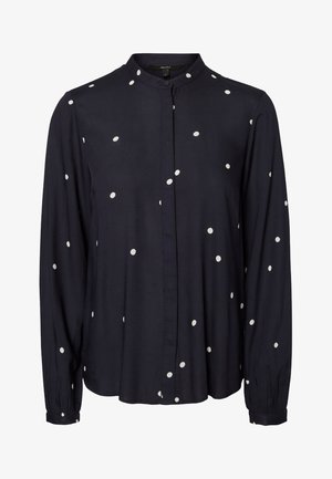 Marineblå bluse med lange ærmer, hvide polkaprikker, mandarinhals og knapper foran.