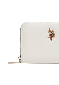 Bílá texturovaná kožená peněženka se zlatým emblémem a zipovým uzávěrem. Disponuje hladkým povrchem a kovovým akcentem.
