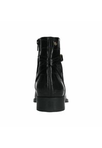 Zwarte leren enkelboot met een krokodillenstructuur, een zijrits en een kruisbanddetail. Lage zwarte hak, elegante vorm en glanzende afwerking.