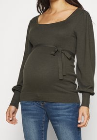 Maglione premaman verde scuro, con scollatura quadrata, maniche lunghe a sbuffo e dettaglio in vita legato. Tessuto in maglia morbido.