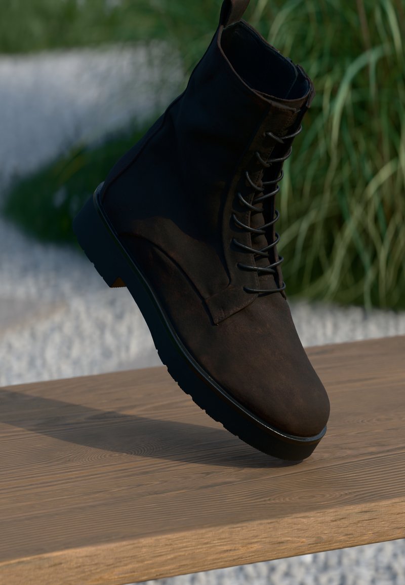 Bottine en cuir marron avec un laçage à l'avant, un bout arrondi et une finition texturée. Équipée d'une semelle en caoutchouc noir et d'un design minimaliste.
