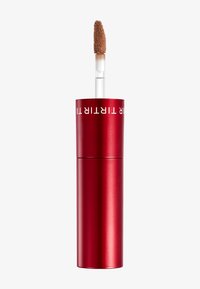 Rød cylindrisk tube med mat finish, med en klar applikatorstang; blød børste-tip; emballagen viser hvidt mærketekst på toppen.