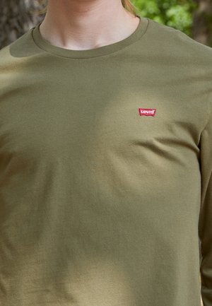 Camiseta de manga larga color verde oliva, hecha de algodón, con un pequeño logo rojo de Levi's en el pecho. Textura suave, cuello redondo.