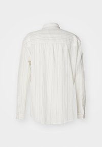 Witte langslavenshirt met verticale grijze strepen, knoopmanchetten en een geplooide schouderpas aan de achterkant. Textuurstof, standaard kraagontwerp.