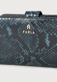 Portofel din piele neagră și bleu-verzui cu model în relief de șarpe. Prezintă un logo auriu și o închidere cu clemă. Textură netedă cu finisaj lucios.