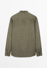 Khaki green long-sleeve shirt displayed from the back, featuring a small collar and buttoned cuffs. Textured fabric visible.