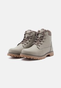 Grey leather hiking boots with brown accents, padded ankle, lace-up design, and rugged rubber sole featuring deep treads for traction.