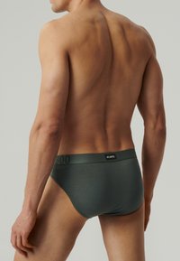 Męskie slipy w ciemnozielonym kolorze, o gładkiej fakturze, elastycznej talii z logo "ATLANTIC", niskim kroju i dopasowanym fasonie.