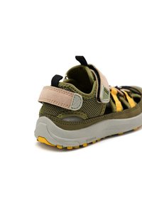 Sandalia exterior multicolor en verde, negro y amarillo. Cuenta con parte superior de malla, correa ajustable y suela de goma texturizada con agarre.