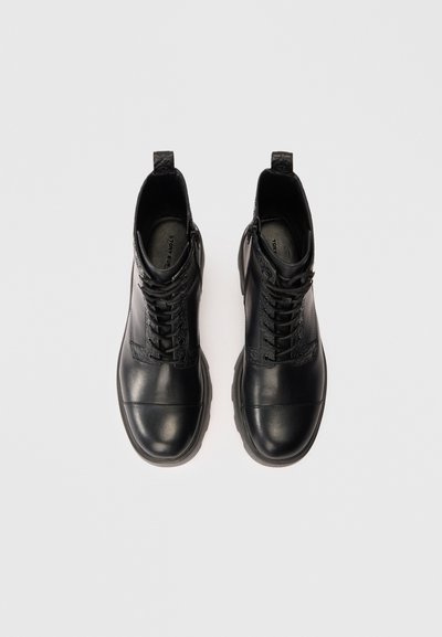 Botas de tobillo de cuero negro con un diseño texturizado, puntera redonda, sistema de cordones y cuello acolchado. Suela de goma para un mejor agarre.