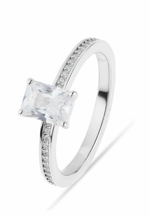 Ring i hvidguld med en stor rektangulær klar ædelsten og mindre runde sten indfattet langs ringen.