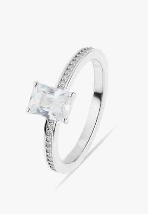 Ring i hvidguld med en stor rektangulær klar ædelsten og mindre runde sten indfattet langs ringen.