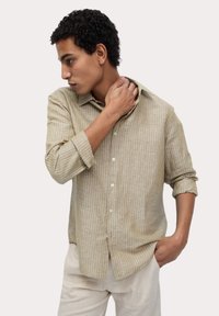 Lichtbruine gestreepte linnen shirt met een losse pasvorm, button-down kraag en opgerolde mouwen, die subtiele textuur en een gladde afwerking toont.