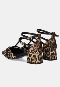 Sandalias de tacón de estampado de leopardo con correas negras, punta afilada y tacón grueso. Presenta detalles en hardware dorado y material texturizado.