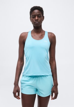 Persona alta vistiendo una camiseta sin mangas deportiva azul claro y pantalones cortos a juego, de pie contra un fondo blanco liso.