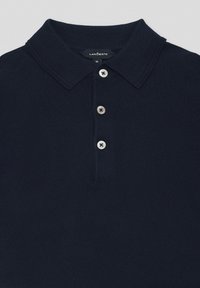 Granatowa koszulka polo wykonana z miękkiej tkaniny, z klasycznym kołnierzykiem, zapięciem na trzy guziki oraz teksturowanym wzorem dzianiny. Widoczna metka z rozmiarem.