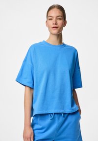 T-shirt en coton oversized bleu clair à manches courtes et col rond, présentant une coupe décontractée et une texture lisse.